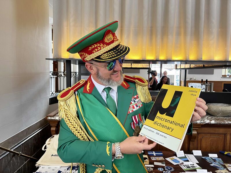 File:Randy Williams of Slowjamastan holding the third edition of the Micronational Dictionary at MicroCon 2023 in Ypres, Belgium.jpg